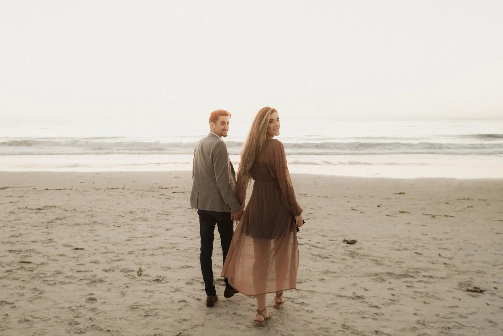 Couple walking the shoreline at dusk