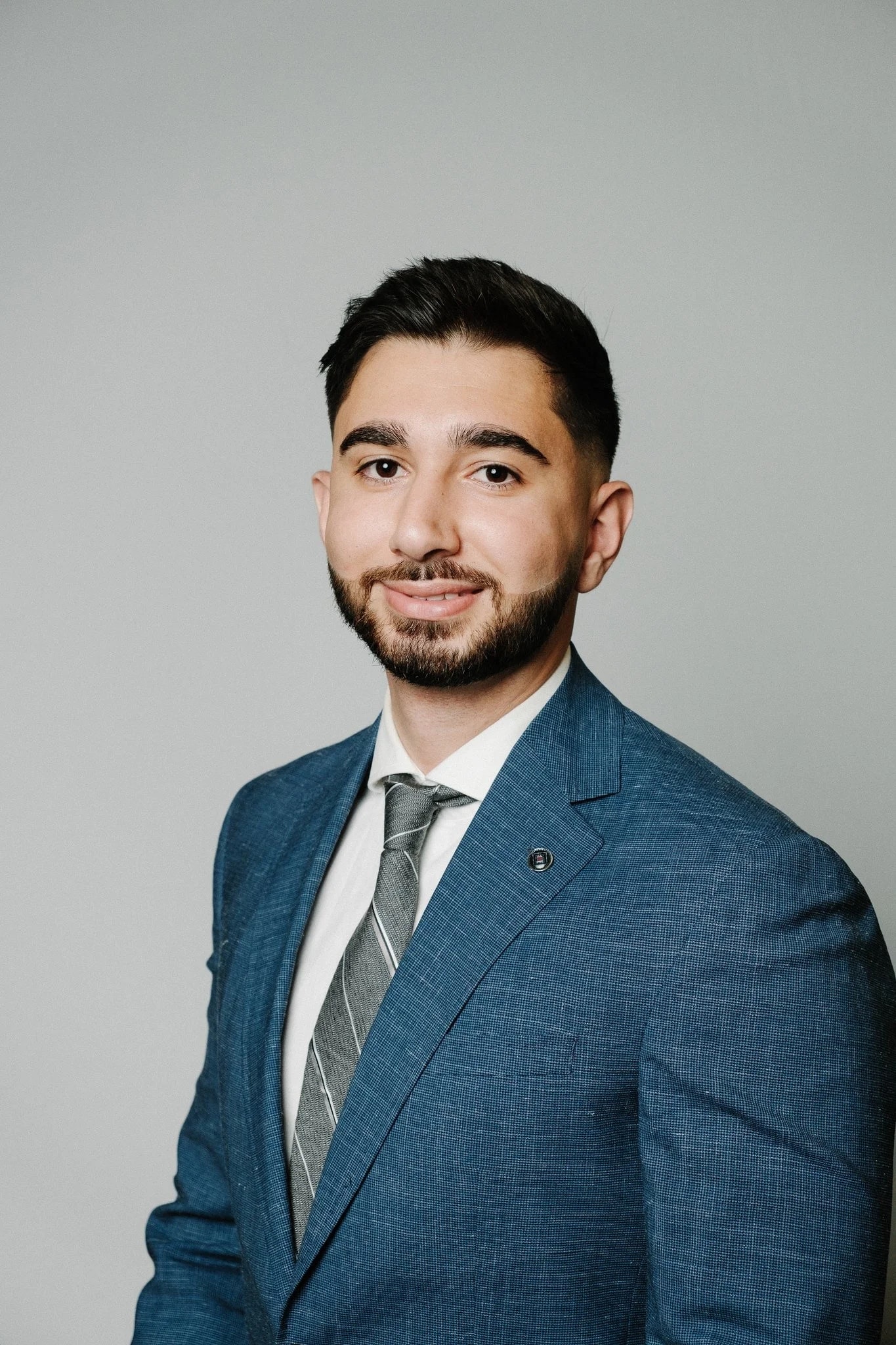 Studio headshot in a blue suit