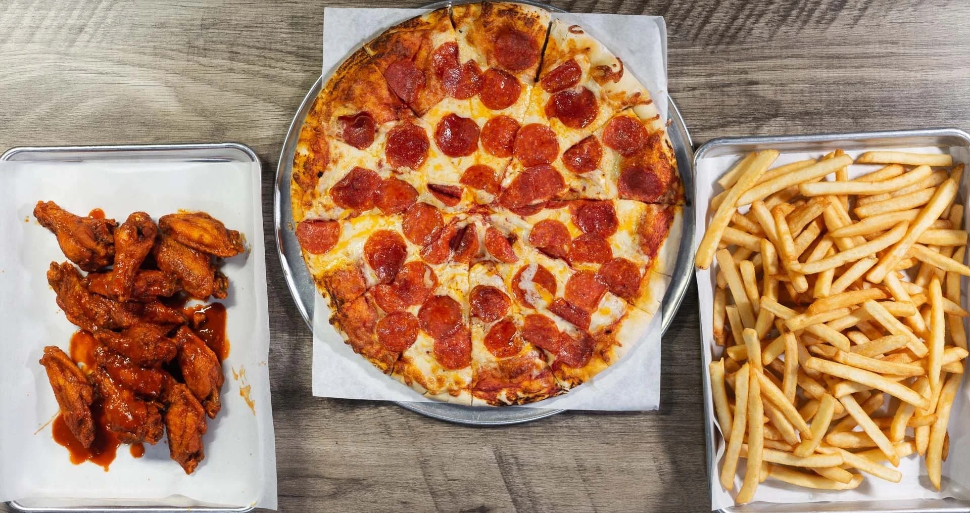 Wings, pizza, and fries — restaurant still life