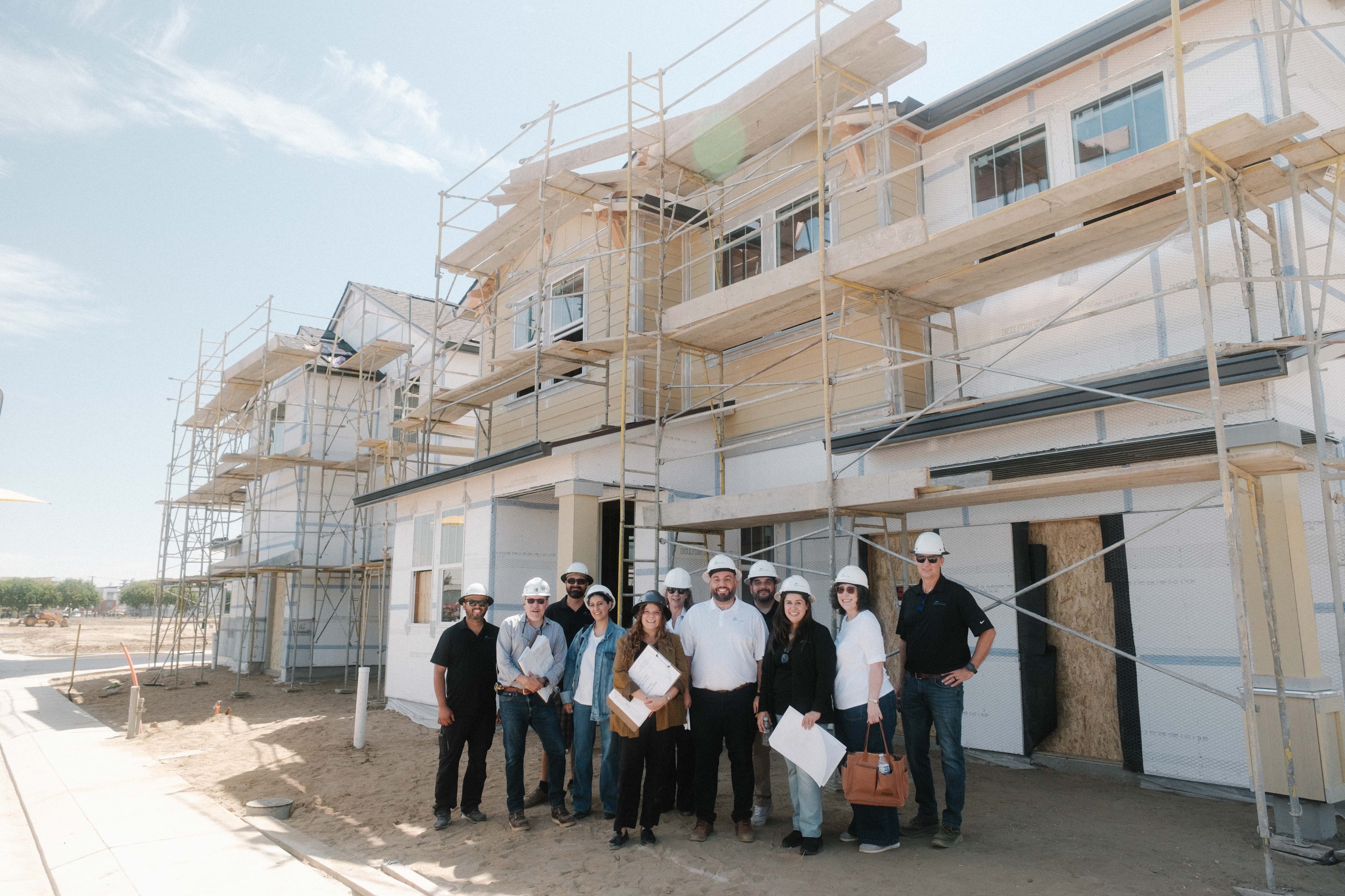 Bright Homes team in front of a house under construction — commercial photography by Steven Lelham in Turlock, CA